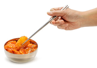 Wall Mural - Hand using chopsticks to pick up Kimchi Korean pickle seasoning on white background, Spicy Kimchi on white PNG file.