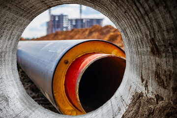 Wall Mural - Insulated pipe. Large metal pipes with a plastic sheath at a construction site. Modern pipeline for supplying hot water and heating to a residential area. Close-up.