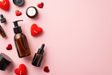 Organic Skincare Cosmetics Concept. Top View Photo Of Amber Glass Pump Bottle Without Label Dropper Bottles Cream Jars And Red Heart Shaped Candles On Isolated Pastel Pink Background With Copyspace