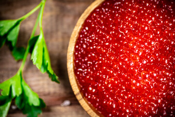 Canvas Print - Red caviar in a plate on the table with parsley. 