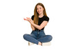 © Asier - Young redhead woman sitting on the floor cut out isolated holding a copy space on a palm.