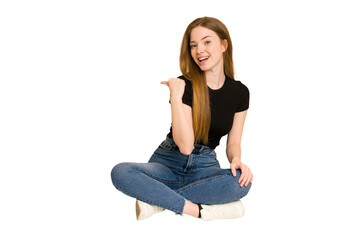 Poster - Young redhead woman sitting on the floor cut out isolated points with thumb finger away, laughing and carefree.