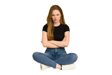 Wall Mural - Young redhead woman sitting on the floor cut out isolated frowning face in displeasure, keeps arms folded.