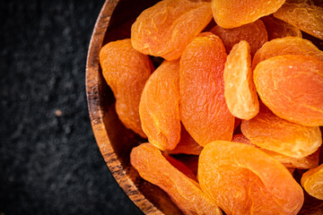 Wall Mural - Dried apricots in a wooden plate on the table. 