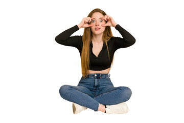 Poster - Young redhead woman sitting on the floor cut out isolated points sideways, is trying to choose between two options.