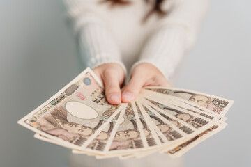 Woman hand holding Japanese Yen banknote stack. Thousand Yen money. Japan cash, Tax, Recession Economy, Inflation, Investment, finance and shopping payment concepts