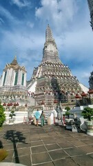 Wall Mural - Couple at Wat Arun temple in Bangkok Thailand during sunset.