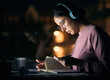 © Jordan C/peopleimages.com - Headphones, research and girl student studying at night for a test, exam or college assignment. University, notes and woman reading while listening to music, radio or podcast in the evening at a desk