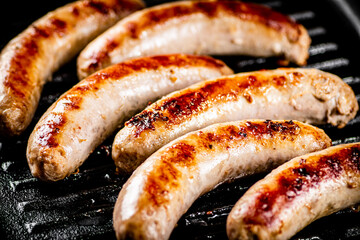 Grilled sausages in a frying pan. 