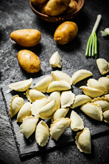 Poster - Potato dumplings on a stone board with green onions. 