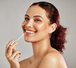 © K. A./peopleimages.com - Woman, smile portrait and apply lipstick for beauty, cosmetics dermatology and skincare wellness in grey background. Female model, face and makeup application or lip balm product for happy self care