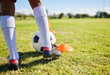 Closeup football kid, grass and training for fitness, sports and balance for control, speed and development. Young soccer player, fast dribbling or exercise feet on grass with cleats in low angle