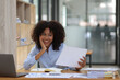 © Wasan - Happy african american businesswoman smiling and laughing from working on a successful project.