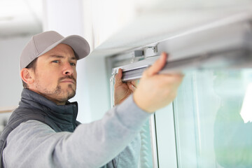 handsome young man installing bay window