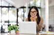 © David - Portrait of Happy Excited young asian woman at workplace office desk, successful Asian female reading good news technology online, employee freelance finance concepts.