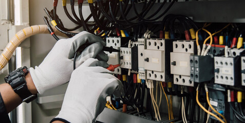 Wall Mural - Electrician engineer tests electrical installations and wires on relay protection system.