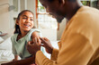 © K. A./peopleimages.com - Father, injury and arm bandage for girl after accident in bedroom. First aid, black family and man apply bandaid or plaster on wound of hurt or injured child for wellness, recovery and healthcare.