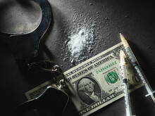 Handcuffs, Dollar Bills And Drug Powder	
