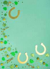 golden horseshoe, gold coins and clover leaves shamrocks on green mint background.