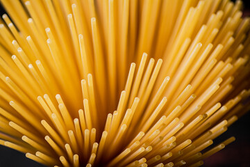 Poster - Not boiled spaghetti dry on a black background.