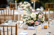 Beautiful table setting with tableware, flowers, candles, accessories and rose centerpiece for a party, wedding reception, gala banquet or other holiday event.
