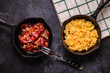 Cooked scrambled eggs and fried bacon in portion pans
