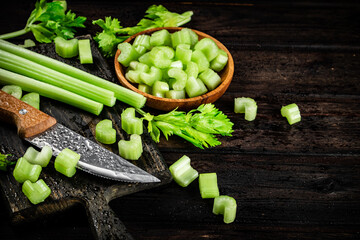 Sticker - Sliced fresh celery. On a dark wooden background.