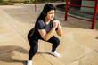© kleberpicui - Woman doing squats outdoors. Fitness, sport, exercising and healthy lifestyle concept