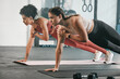 © Delcio/peopleimages.com - Gym floor, health and exercise woman doing arm plank workout, performance training or core muscle building. Body self care, commitment and wellness for team, people or friends on fitness class ground