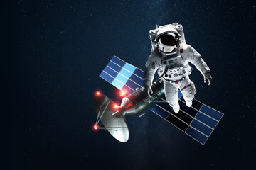 Wall Mural - astronaut in a white spacesuit in space on the background of a satellite. exploration of space and o