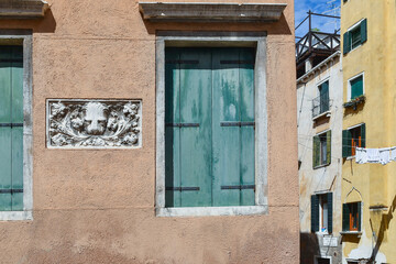 Sticker - Detail of the exterior of Palazzo Tamossi decorated with a bas relief depicting the St Mark's Lion between a pair of closed windows, Rio de Sant'Aponal, sestiere of San Polo, Venice, Italy