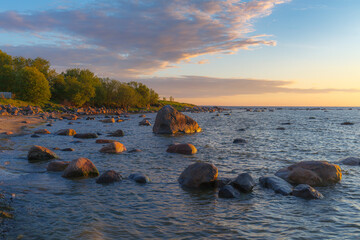Wall Mural - Rocky shore with stones sinking in the sea water. Sunset, orange light, Estonia.