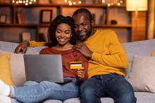 Happy Black Couple Banking From Home, Using Laptop, Credit Card