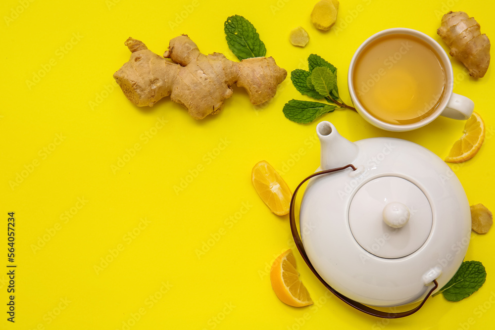 Composition with teapot, cup of tea,  mint and lemon on yellow background