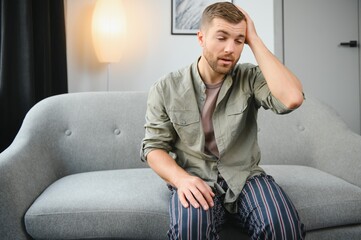 Wall Mural - Man having a headache at home