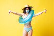 young dissatisfied brunette girl in a blue swimsuit with a swimming inflatable ring puts on a medical mask