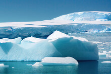 Blue And White Icebergs Floating In Antarctica