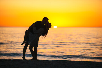 Wall Mural - Young couple in love on the beach summer vacation. Happy man and woman enjoy time together