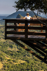  middle-aged woman on the wooden deck on the mountain in Brazil