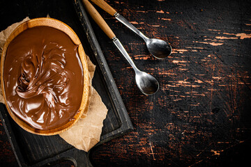 Wall Mural - Hazelnut butter in a plate on a cutting board with paper.