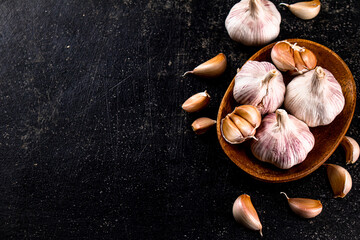 Poster - Fresh garlic on a wooden plate. 