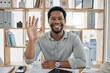 © Lou W/peopleimages.com - Business, video call and black man wave in office, conference or meeting. Greeting, hello and portrait of happy male employee from Nigeria waving in webinar, workshop or online chat in workplace.