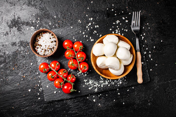 Canvas Print - Mozzarella cheese in a plate on a stone board with tomatoes and spices.