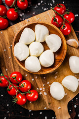 Poster - Mozzarella cheese on a cutting board with spices and tomatoes. 