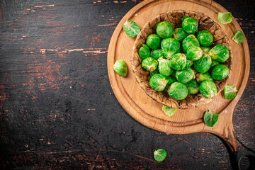 Poster - Brussel cabbage in a basket on a cutting board.