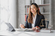 Attractive young female asia lawyer working with contract papers and online consulting with the new law of real estate business.  Law, legal services, advice, Justice, legislation