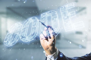 Wall Mural - man hand with pen writes code word hologram on blurred office background, artificial intelligence an