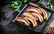 Grilled sausages in a frying pan with parsley. 