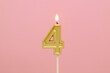© Valerii Evlakhov - Burning golden candle on pink background, number 4