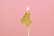 Burning Golden Candle On Pink Background, Number 4